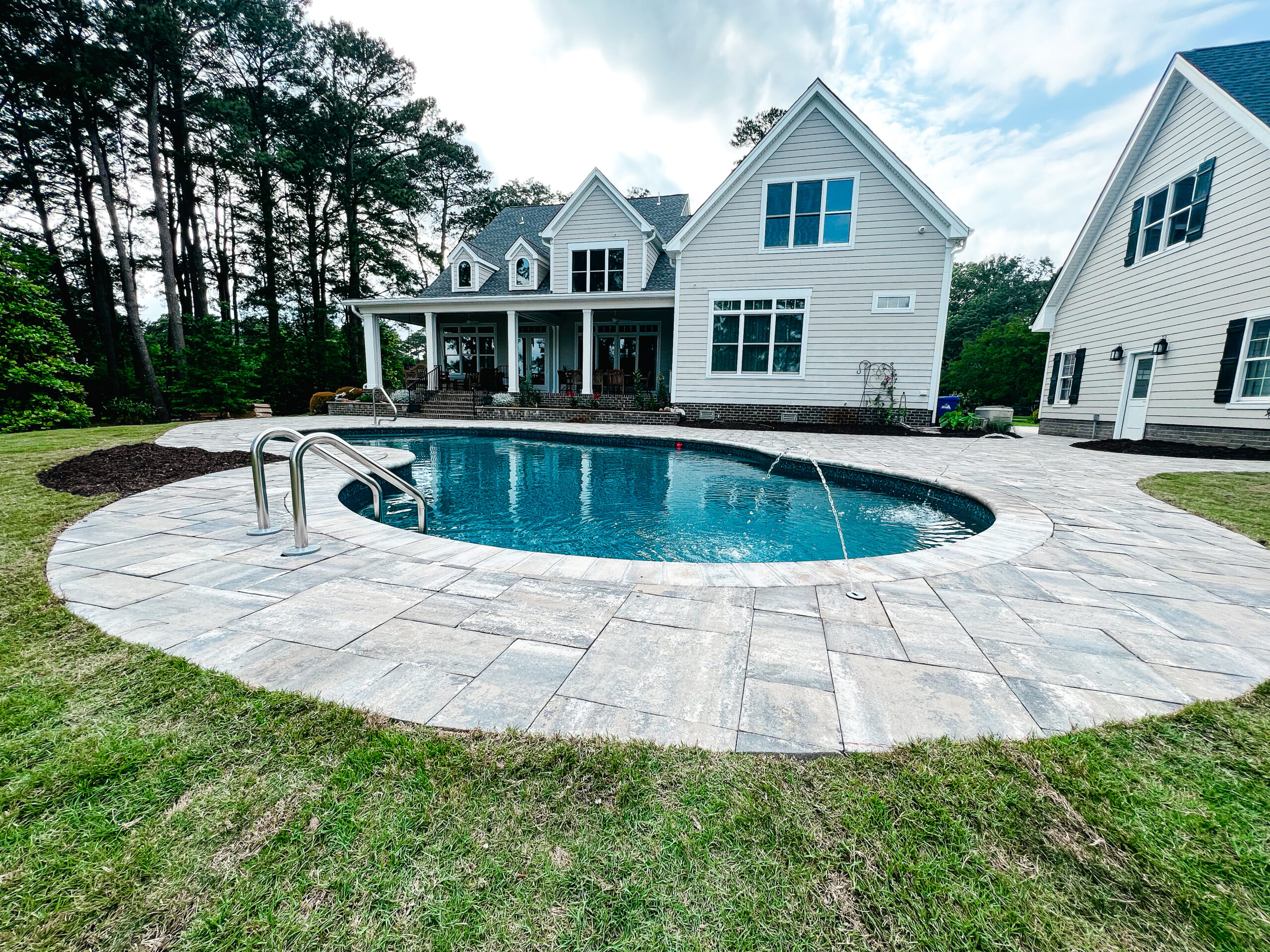 in-ground pool with house in background